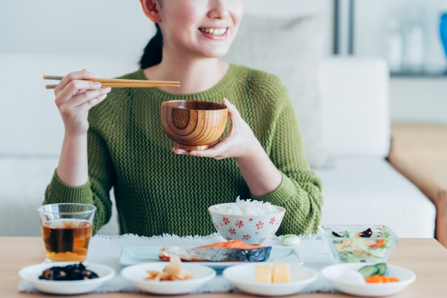 家政婦の作った料理を食べる笑顔の女性