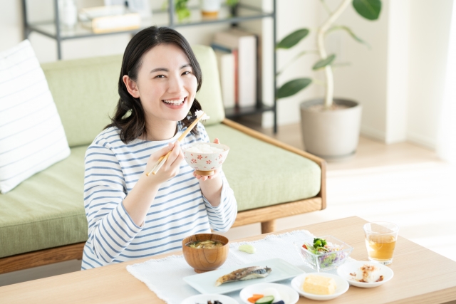 笑顔で料理を食べる女性