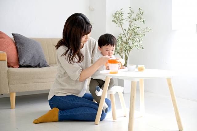 男の子に食事をさせるお母さん