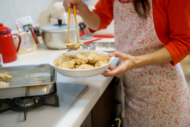 揚げ物をさらに盛り付ける家事代行スタッフ