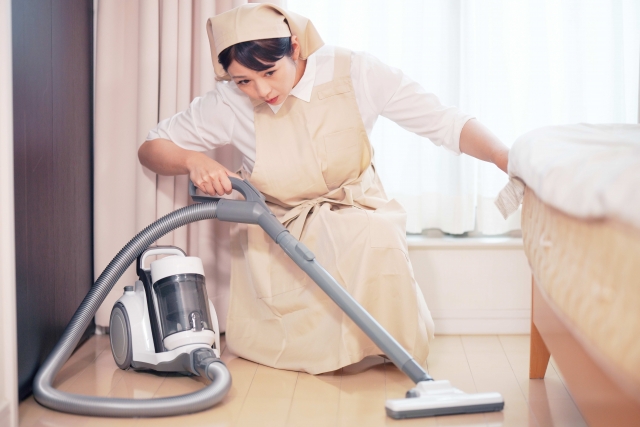 掃除機をかける家政婦